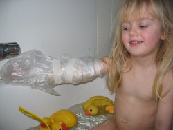 In bad met de arm in een plastic zak gewikkeld